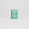 Lifestyle image of Zippo Human Tree Design High Polish Green Windproof Lighter standing in a grey scene.