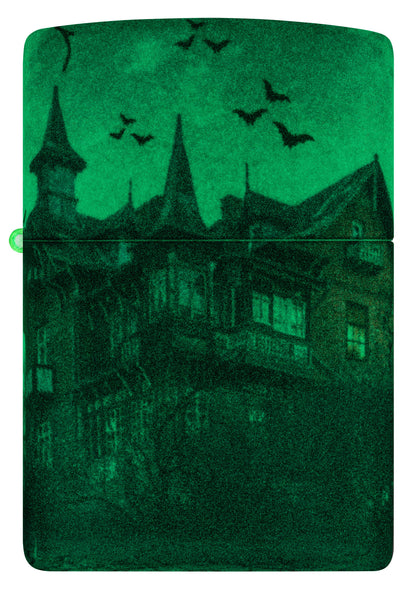Front view of Zippo Horror House Glow in the Dark Matte Windproof Lighter glowing in the dark.