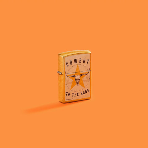 Lifestyle image of Zippo Buck Wear Reg Street Brass Windproof Lighter on an orange background.
