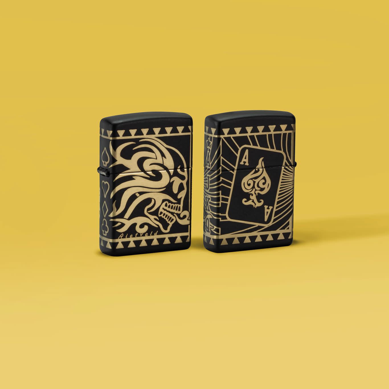 Glamour shot of two Zippo Rick Rietveld Laser 360 Black Matte Windproof Lighters standing in a yellow scene.