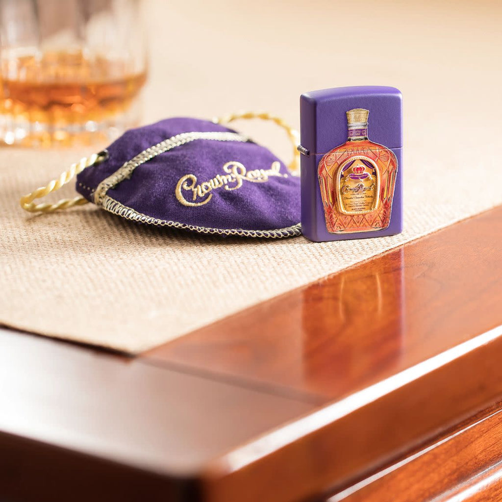Lifestyle image Crown Royal® Purple Matte Windproof Lighter and Crown Royal® Pouch on a side stand with a drink.