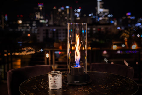 Lifestyle image of Zippo FlameScapes™ Spiral Fire Feature XL in black, lit on a table with the fuel canister