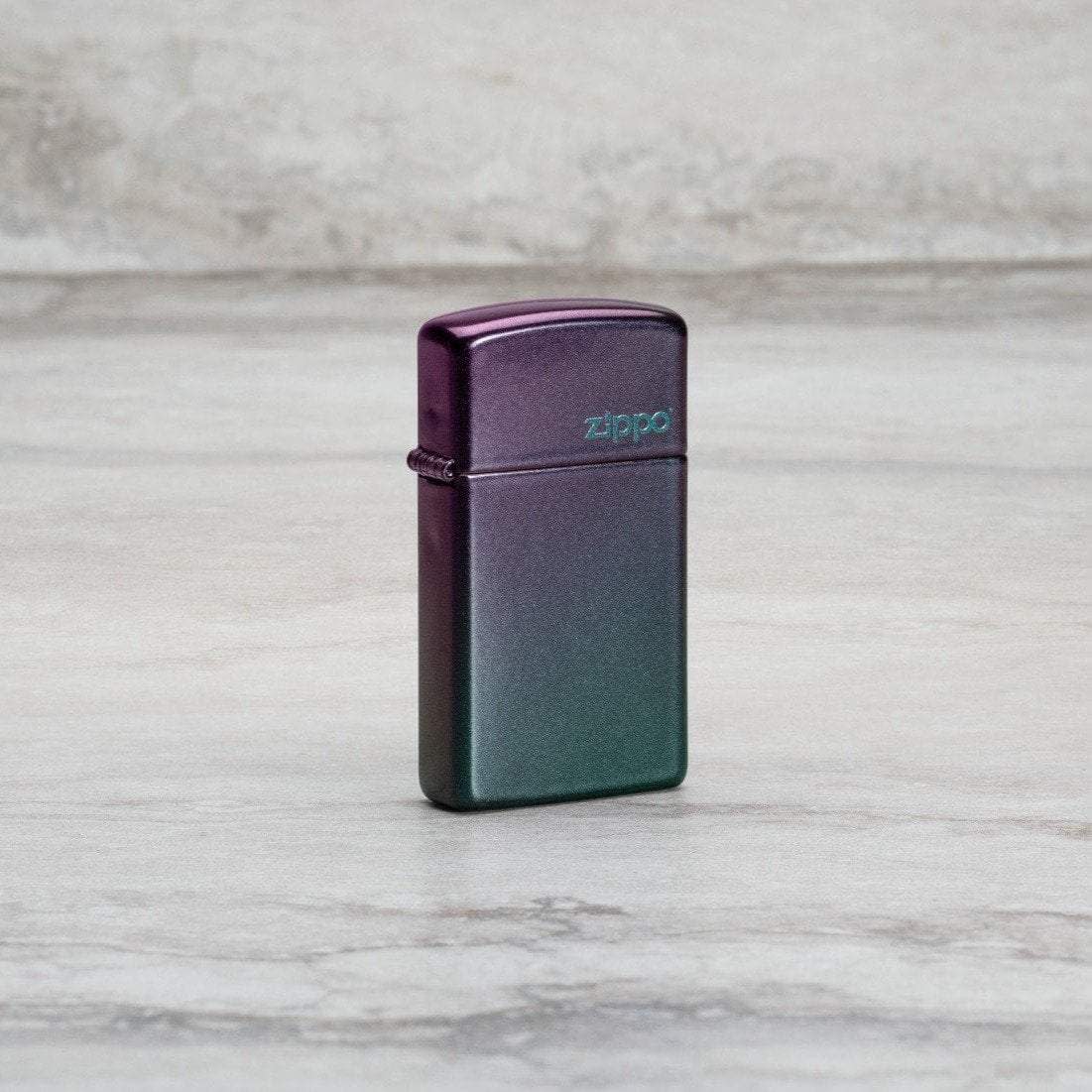 Lifestyle image of SlimÂ® Iridescent Zippo Logo Windproof Lighter standing at an angle on a marble surface