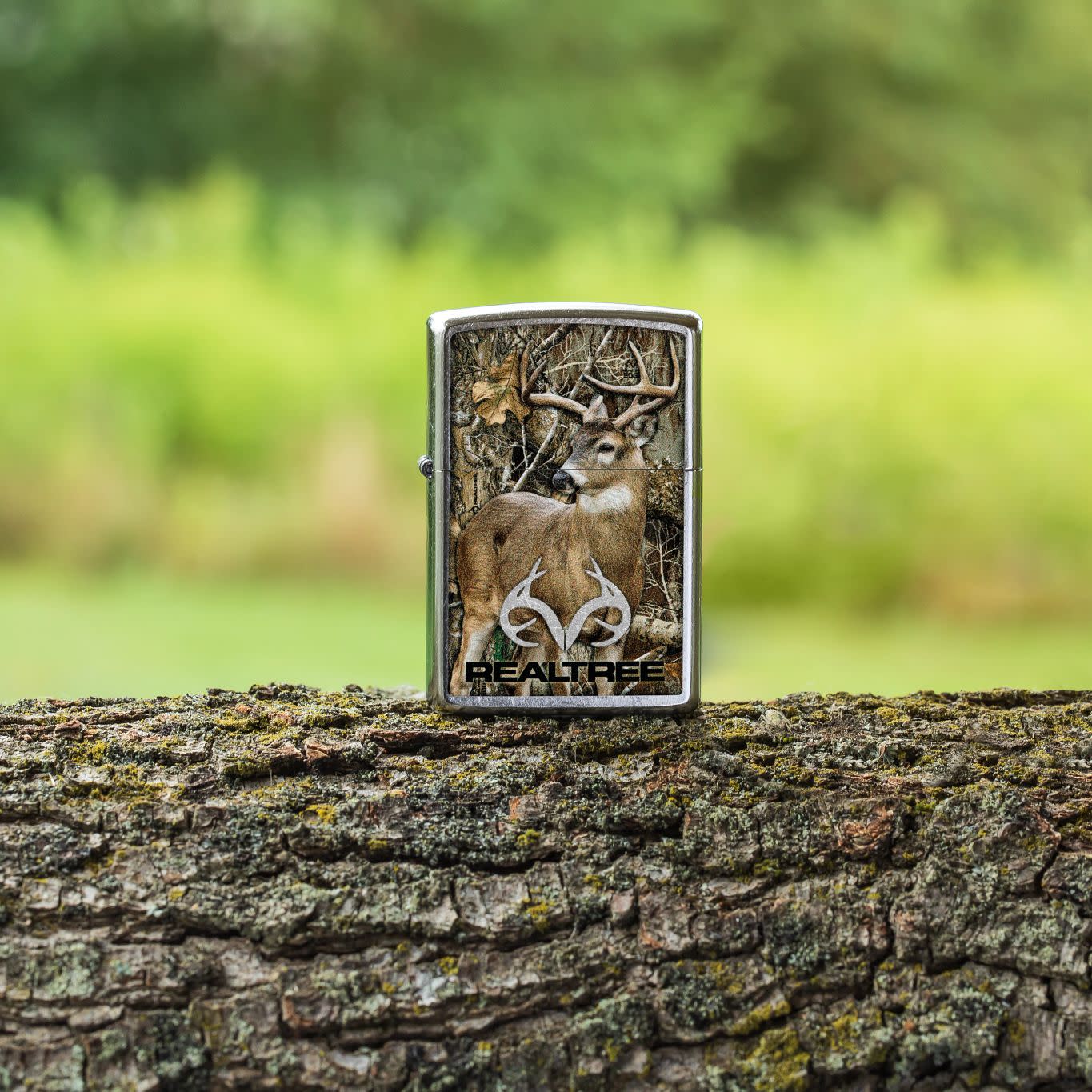 Lifestyle image of Zippo RealtreeÂ® Buck Design Street Chrome Windproof Lighter standing on a tree limb.