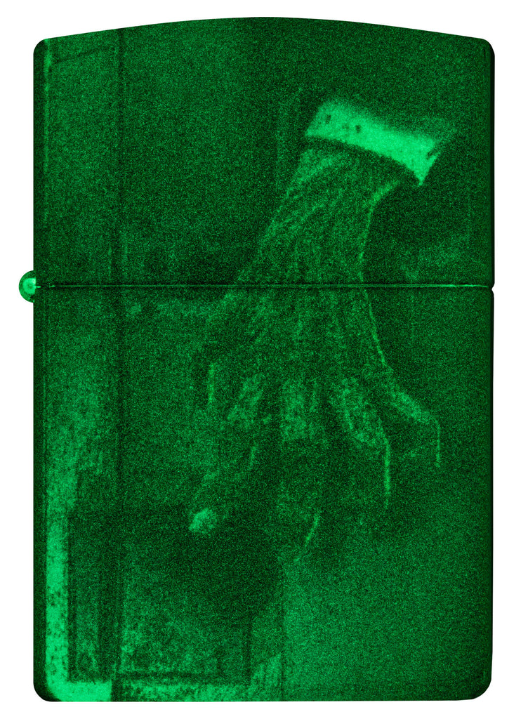 Front shot of Glow In the Dark Zombie Hand Windproof Lighter glowing.