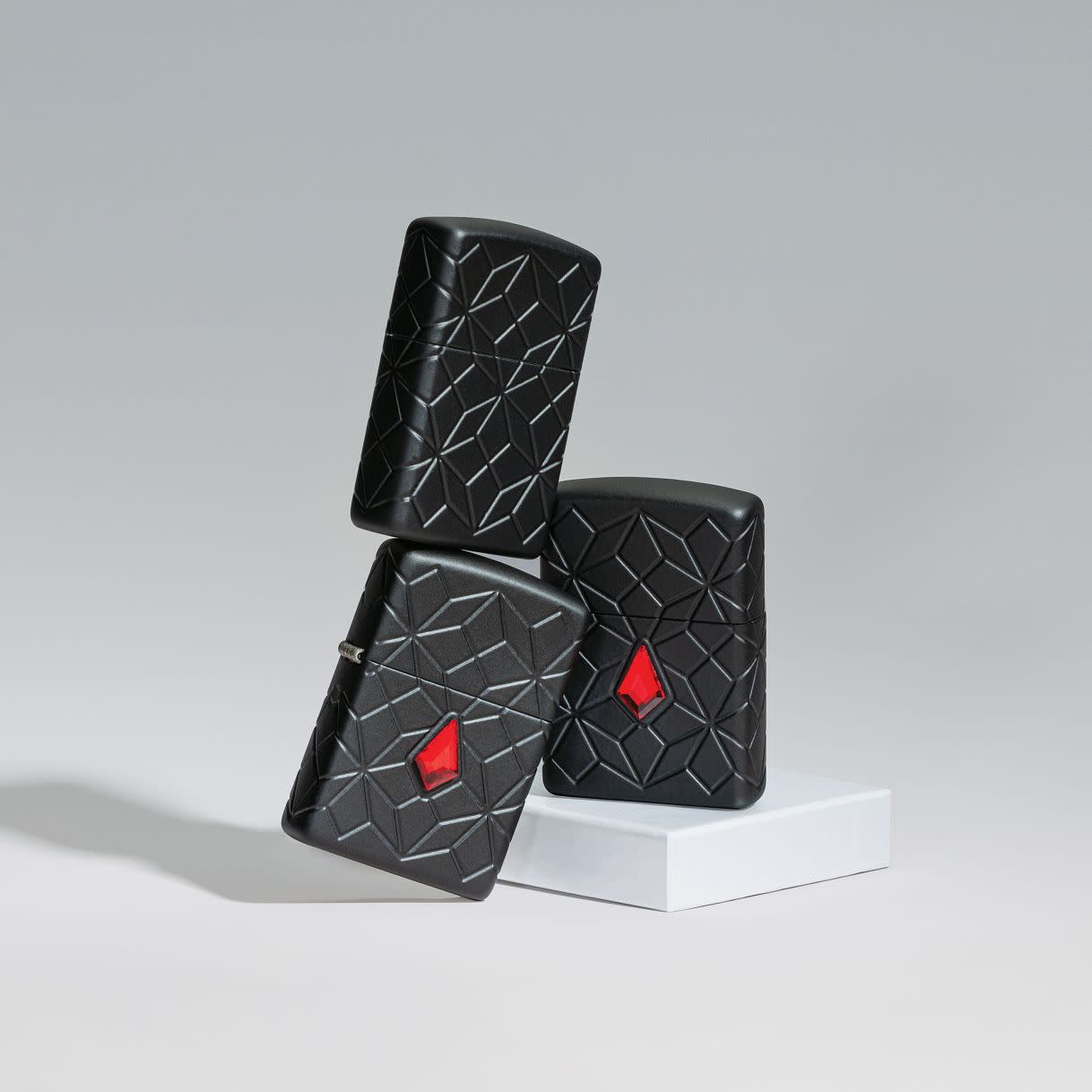 Lifestyle image of Zippo Crystal Design ArmorÂ® Black Matte Windproof Lighters standing on top of each other, showing all angles of the lighter.
