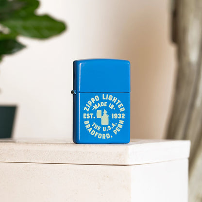 Lifestyle image of Zippo Seal Design Sky Blue Matte Windproof Lighter standing in front of a plant.