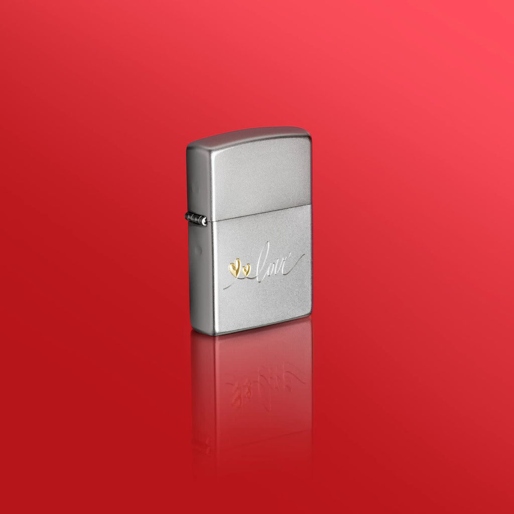 Lifestyle image of Zippo Love Design Satin Chrome Windproof Lighter standing in a red scene.