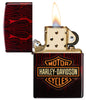 Zippo Harley-Davidson® 540 Tumbled Brass Windproof Lighter with its lid open and lit.