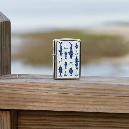 Lifestyle image of Zippo Off the Hook Design Street Chrome Windproof Lighter standing on a wooden railing with a blurred seascape in the background.