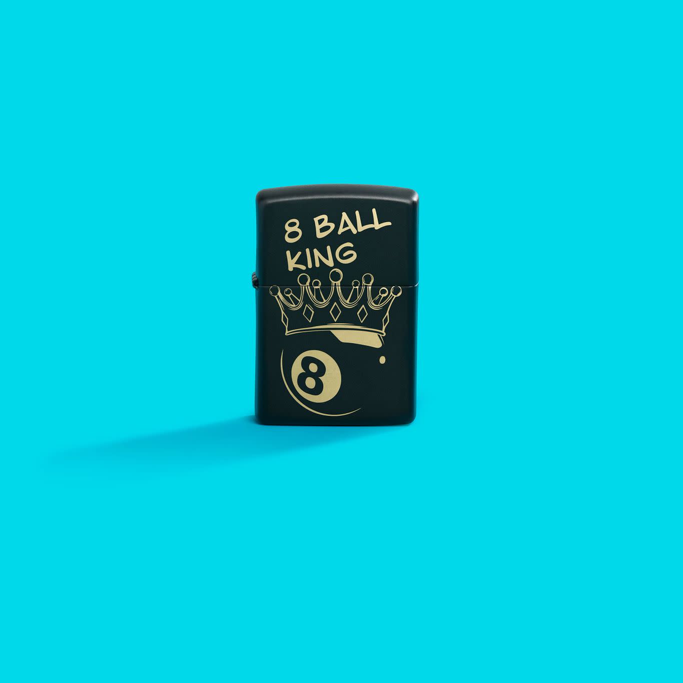 Lifestyle image of Zippo Billiards Champion Design Black Matte Windproof Lighter standing in a blue scene.