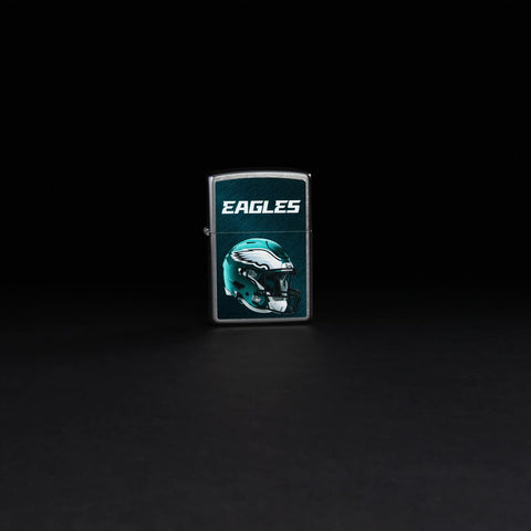 Lifestyle image of NFL Philadelphia Eagles Helmet Street Chrome Windproof Lighter standing in a black background.