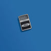 Lifestyle image of Ford Logo Diamond Plate Metal Design Street Chrome Windproof Lighter laying on a blue background.