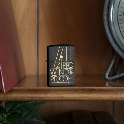 Lifestyle image of Zippo Line Art Zippo Design Black Crackle Windproof Lighter standing on a shelf beside a book and a clock.