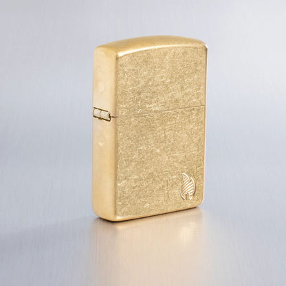 Lifestyle image of Zippo ArmorÂ® Series Flame Tumbled Brass Windproof Lighter on a light gray background.