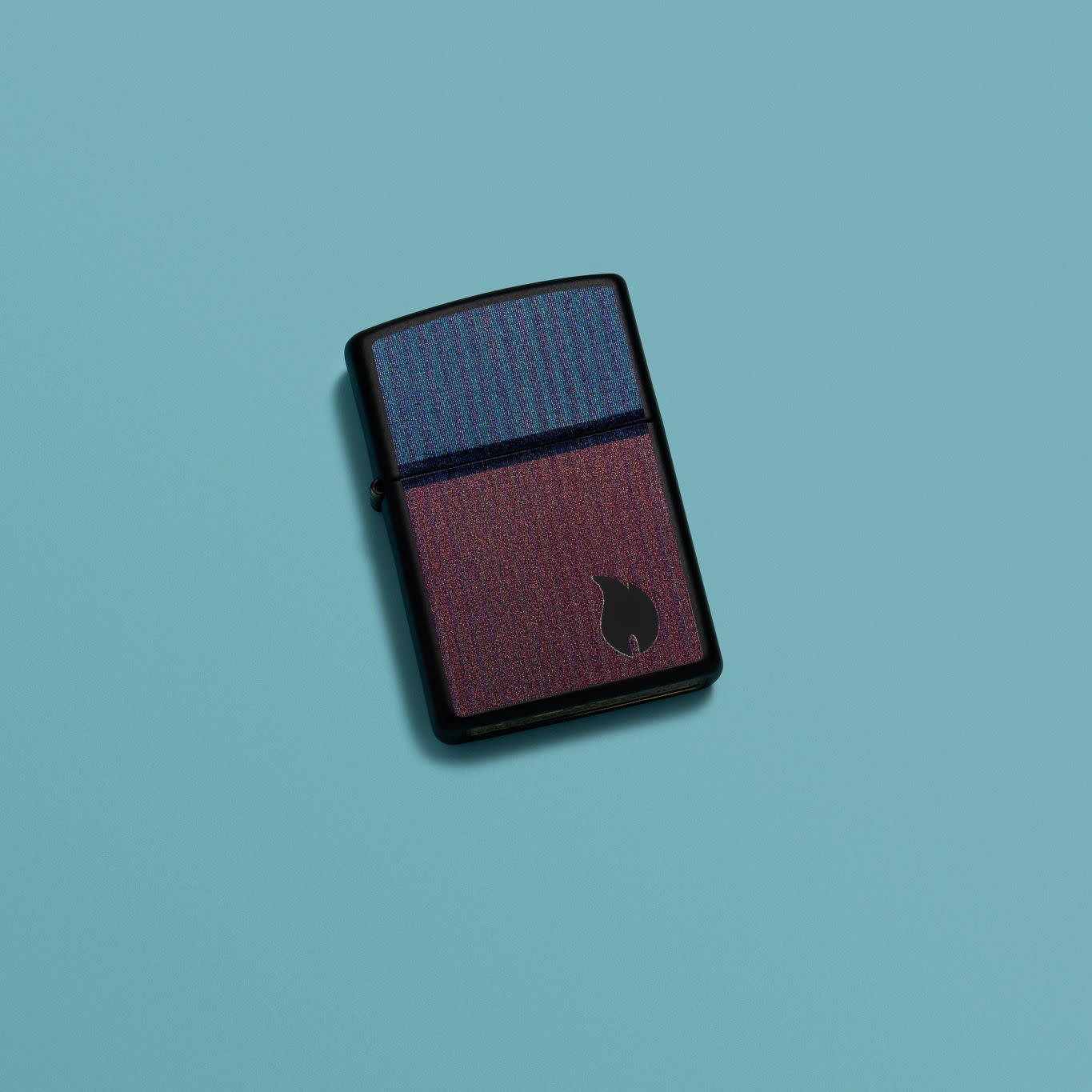 Lifestyle image of Zippo Color Block Flame Design Black Matte Windproof Lighter in a blue scene.