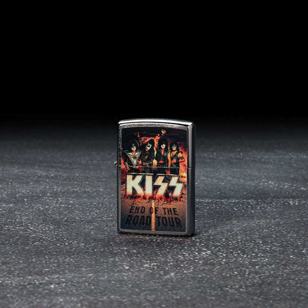Lifestyle image of KISS Design End of the Road Tour Street Chrome™ Windproof Lighter standing in a dark scene.