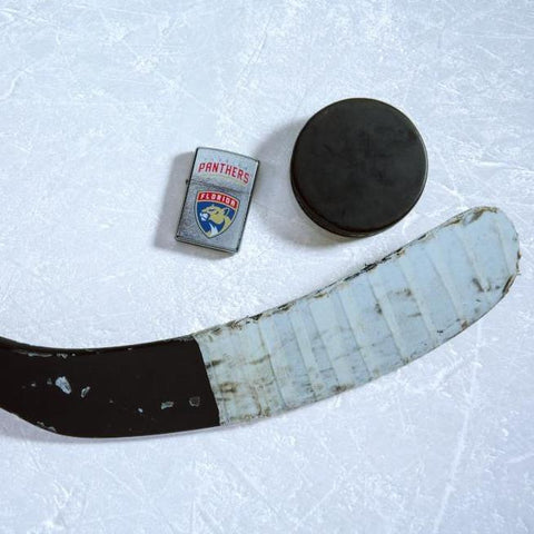 Lifestyle image of the NHL Florida Panthers Street Chrome Windproof Lighter laying on ice with a hockey puck and stick