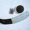 Lifestyle image of the NHL Ottawa Senatorsr Street Chrome Windproof Lighter laying on ice with a hockey puck and stick