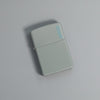 Lifestyle image of Classic Flat Grey Zippo Logo Windproof Lighter laying on a grey surface