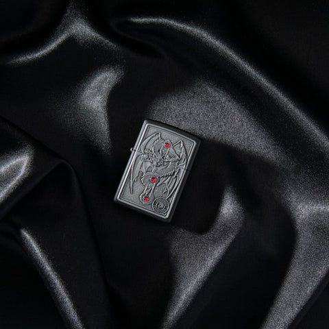 Lifestyle image of Anne Stokes Gothic Guardian Emblem Black Matte Windproof Lighter laying on black silk.