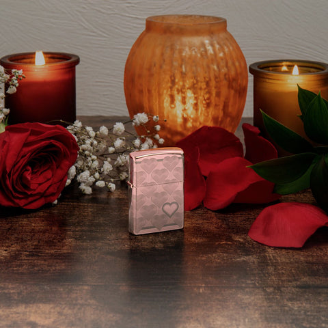 Lifestyle image of Heart Design High Polish Rose Gold Windproof Lighter standing on a table with lit candles and red roses.