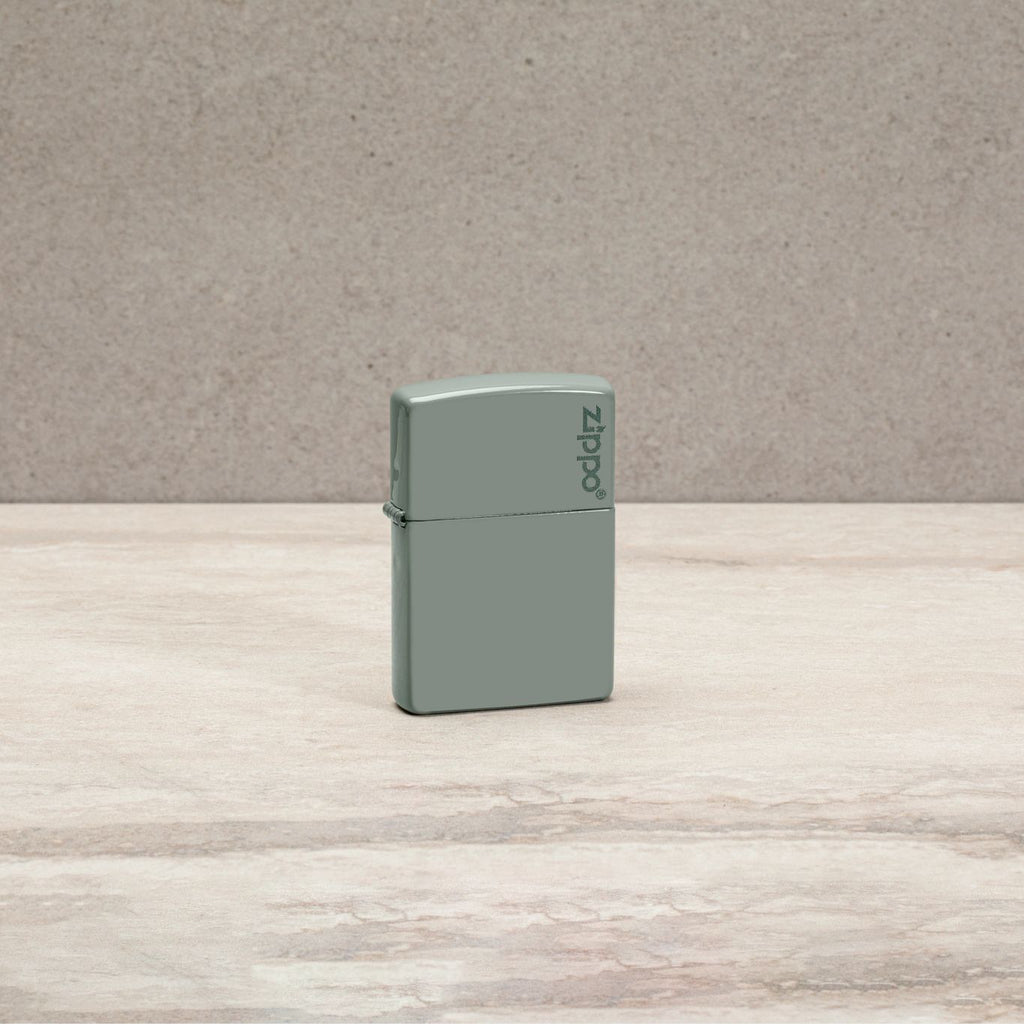 Lifestyle image of Classic Sage Zippo Logo Windproof Lighter standing on a countertop.