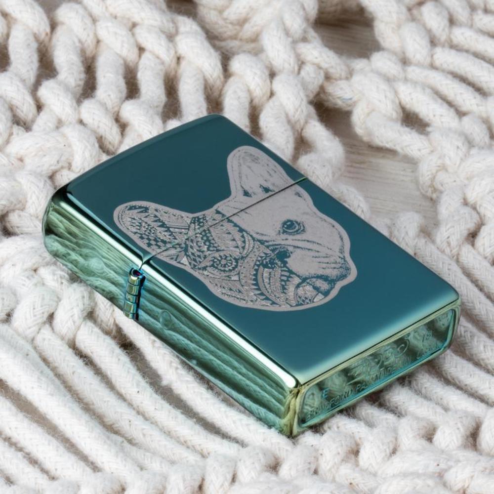 Lifestyle image of French Bulldog Design High Polish Green Windproof Lighter laying on a blanket