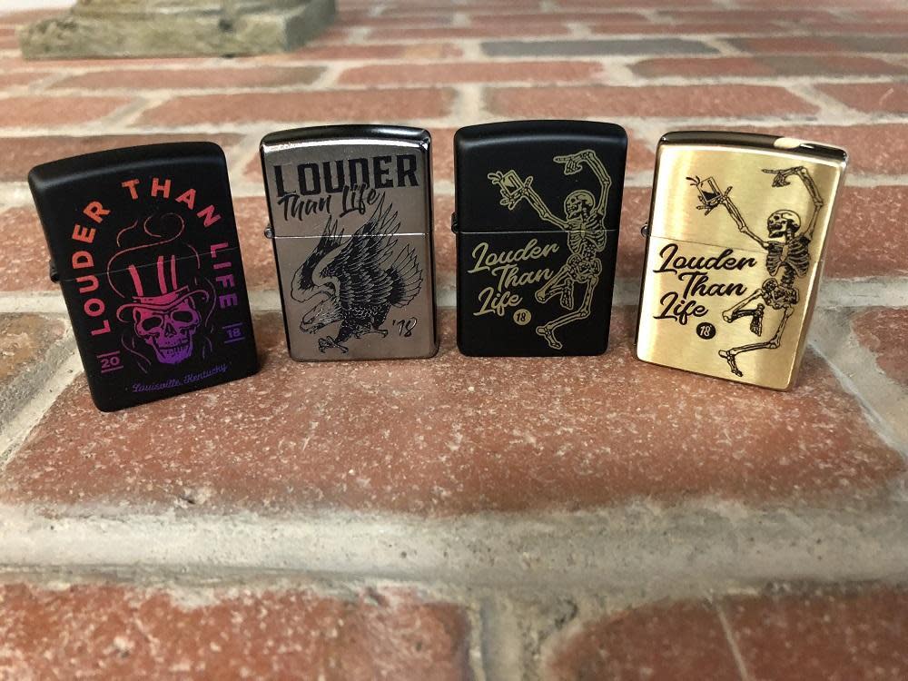 Front view of the Louder Than Life 18 Eagles Dare Lighter closed standing on a brick background