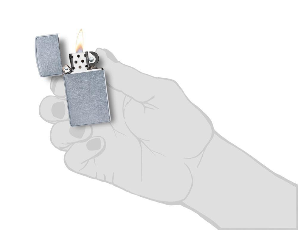 SlimÂ® Street Chromeâ„¢ Windproof Lighter lit in hand.