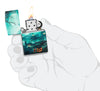 Zippo Graveyard Design 540 Color Windproof Lighter lit in hand.