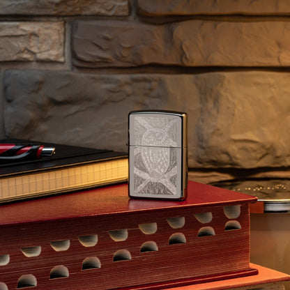 Lifestyle image of John Smith Gumbula Bird High Polish Teal Windproof Lighter standing on a red book with glasses laying next to it
