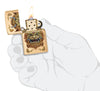 Zippo Foo Dog Design Brushed Brass Windproof Lighter lit in hand.