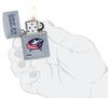 NHL Columbus Blue Jackets Street Chrome™ Windproof Lighter lit in hand