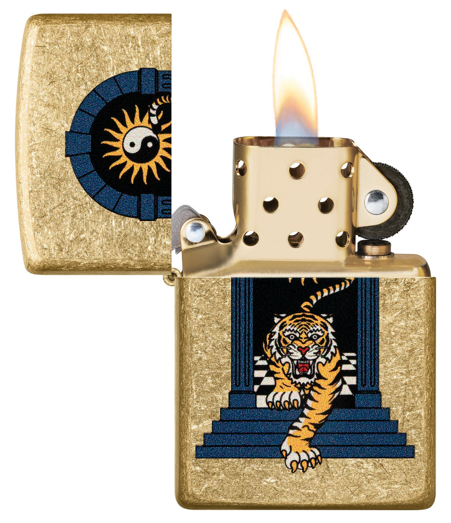 Zippo Tiger Tattoo Design Tumbled Brass Windproof Lighter with its lid open and lit.