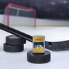 Lifestyle image of the NHL® Nashville Predators™ Street Chrome™ Windproof Lighter standing with a hockey puck and hockey stick, with a hockey net in the background.