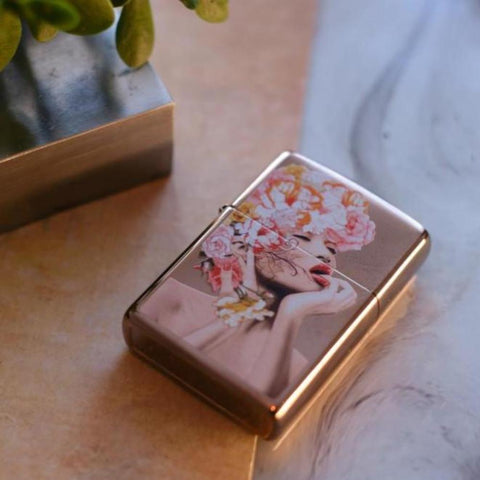Lifestyle image of Floral Woman Design Rose Gold Windproof Lighter laying down at an angle