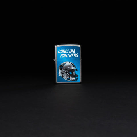 Lifestyle image of NFL Carolina Panthers Helmet Street Chrome Windproof Lighter standing in a black background.