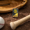 Lifestyle image of MLB™ San Diego Padres™ Street Chrome™ Windproof Lighter laying on a baseball field with a glove, ball, and bat.