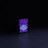 Glamour shot of Zippo Harley-Davidson Black Light Logo Black Matte Windproof Lighter glowing with a black light,