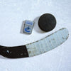 Lifestyle image of the NHL Vancouver Canucksr Street Chrome Windproof Lighter laying on ice with a hockey puck and stick