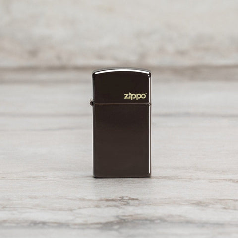 Lifestyle image of Slim® Brown Zippo Logo Windproof Lighter standing on a marble surface