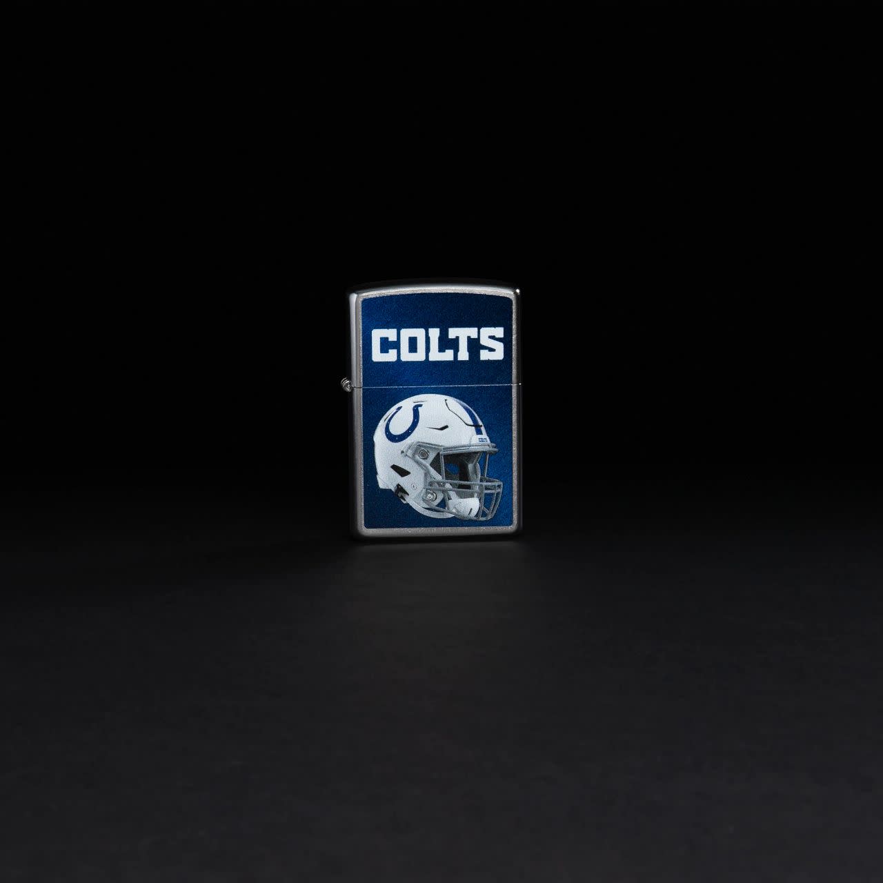 Lifestyle image of NFL Indianapolis Colts Helmet Street Chrome Windproof Lighter standing in a black background.