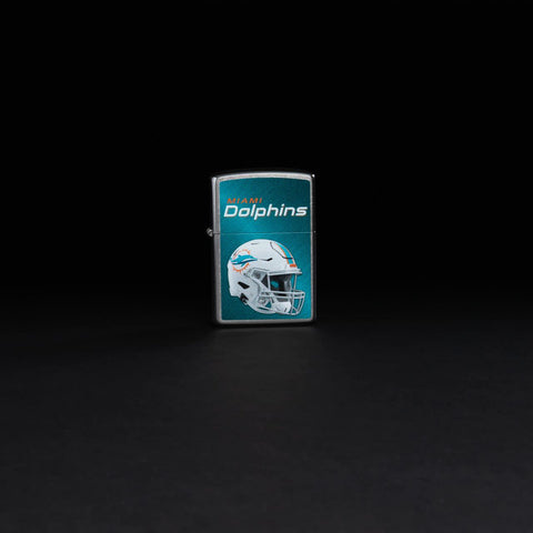 Lifestyle image of NFL Miami Dolphins Helmet Street Chrome Windproof Lighter standing in a black background.