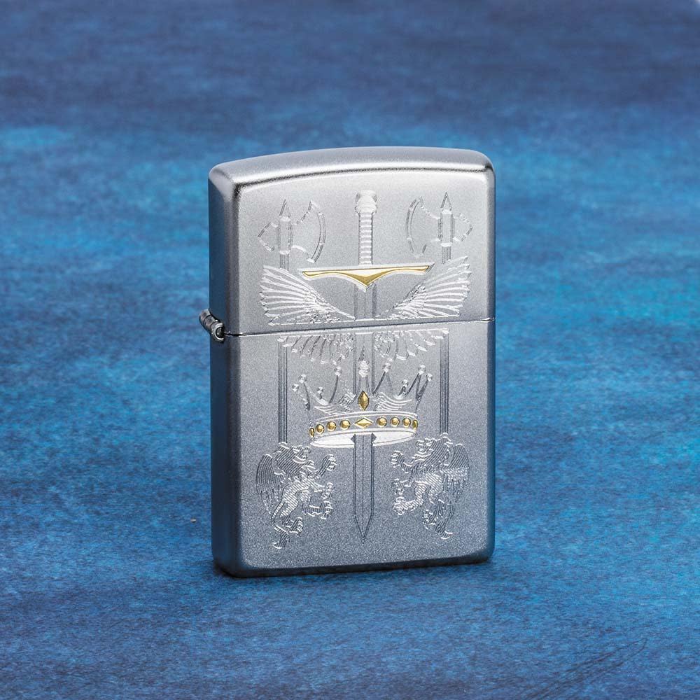 Lifestyle image of Sword Design Satin Chrome Windproof Lighter standing on a blue surface