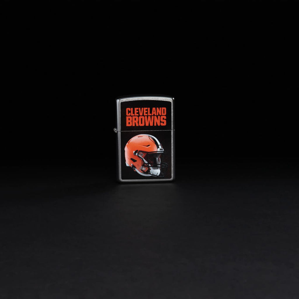 Lifestyle image of NFL Cleveland Browns Helmet Street Chrome Windproof Lighter standing in a black background.