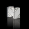 Lifestyle image of two Sterling Silver Diagonal Filigree Design Windproof Lighter in a black mirrored scene. One lighter is showing the front of the design while the other lighter shows the back.