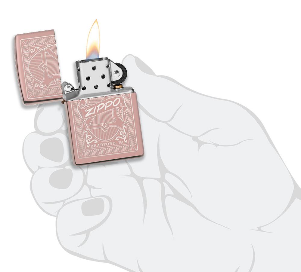 Reimagine Zippo High Polish Rose Gold Windproof Lighter lit in hand