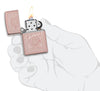 Reimagine Zippo High Polish Rose Gold Windproof Lighter lit in hand
