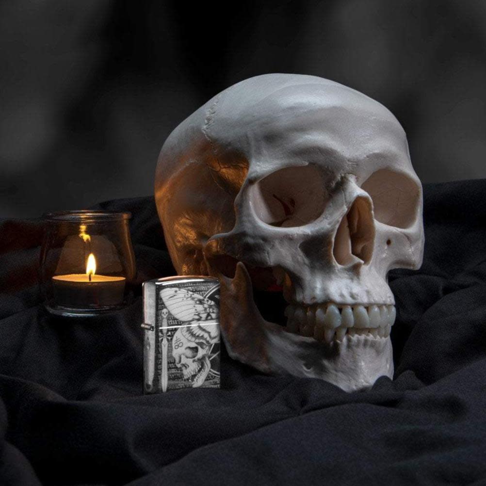 Lifestyle image of Hawkmoth High Polish Black Windproof Lighter with a skull and candle